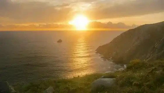 Atardecer desde Finisterre y un hombre sobre una roca en la costa de Finisterre