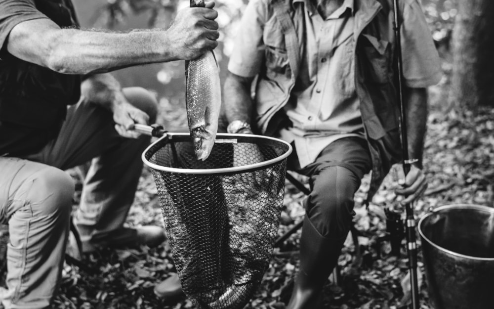 Foto de dos pescadores mostrando la pieza pescada